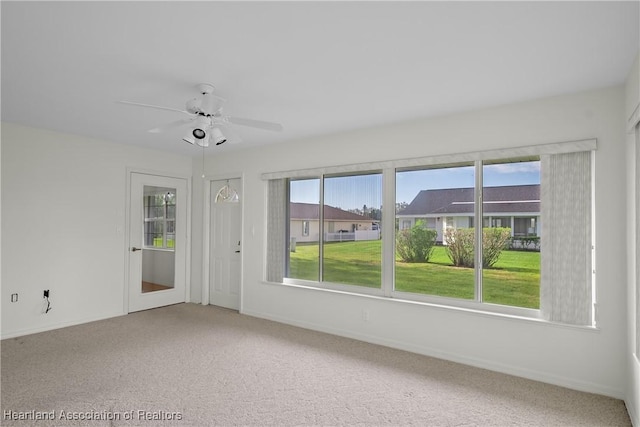 carpeted spare room featuring ceiling fan