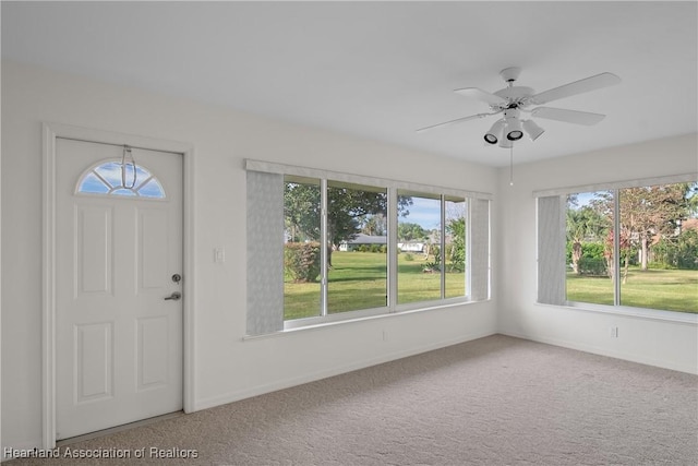 carpeted foyer with a wealth of natural light and ceiling fan