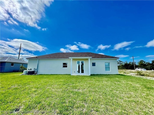 1256 Washington Blvd NE, Lake Placid, FL 33852 - rear view of house featuring a yard, french doors, stucco siding, and central AC