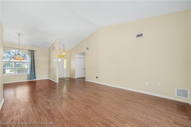 unfurnished living room featuring hardwood / wood-style flooring and vaulted ceiling