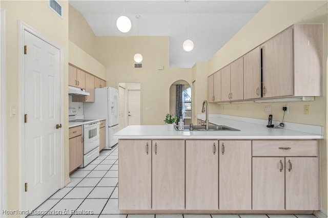 kitchen featuring light brown cabinets, white appliances, sink, hanging light fixtures, and light tile patterned floors