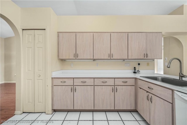 kitchen featuring dishwasher, light brown cabinets, light tile patterned flooring, and sink