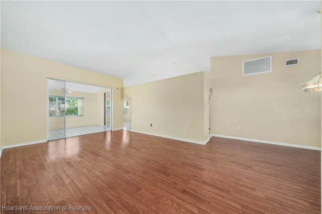 empty room with ceiling fan, wood-type flooring, and vaulted ceiling