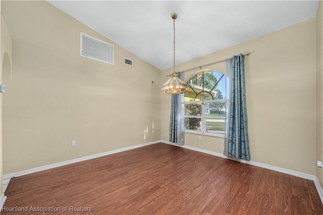 unfurnished dining area with hardwood / wood-style floors, lofted ceiling, and an inviting chandelier