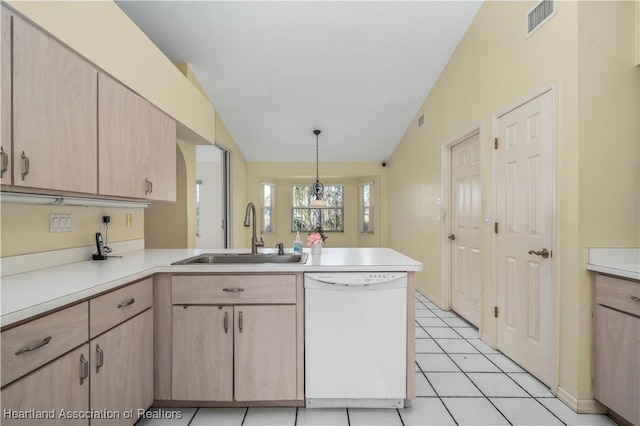 kitchen featuring sink, hanging light fixtures, kitchen peninsula, white dishwasher, and light brown cabinetry