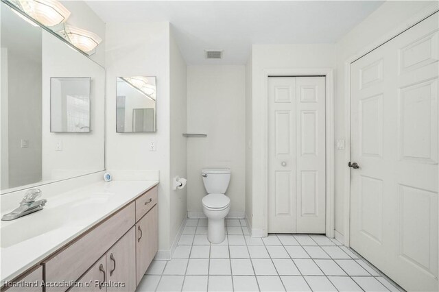 bathroom featuring tile patterned flooring, vanity, and toilet