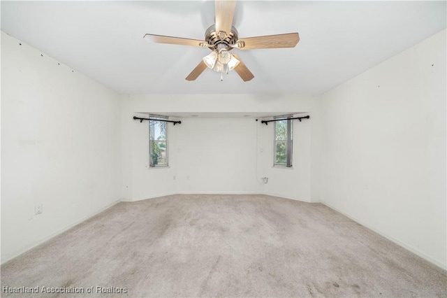 carpeted spare room featuring ceiling fan and a healthy amount of sunlight