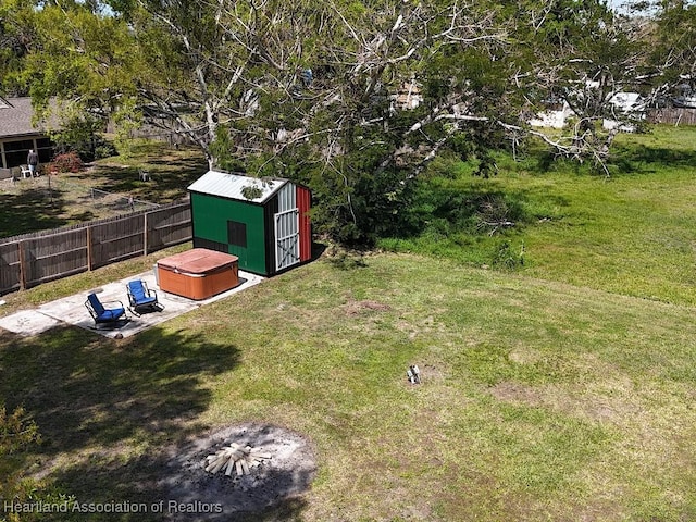 view of yard with a patio, a shed, an outdoor structure, and a fenced backyard