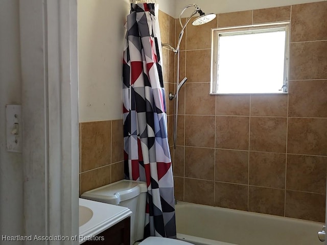 bathroom with shower / tub combo, vanity, toilet, and tile walls