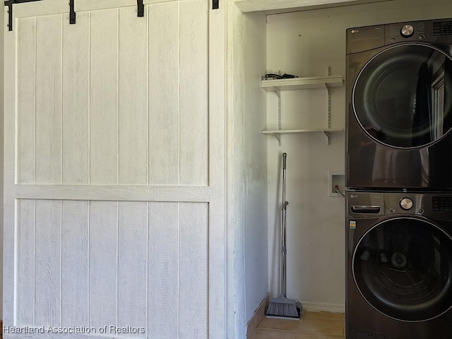 washroom with tile patterned flooring and stacked washer and clothes dryer