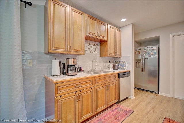 kitchen featuring tasteful backsplash, sink, stainless steel appliances, and light hardwood / wood-style floors