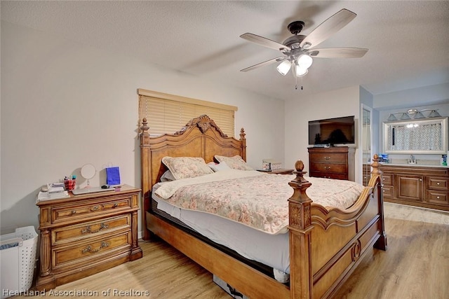 bedroom featuring a textured ceiling, light hardwood / wood-style flooring, and ceiling fan