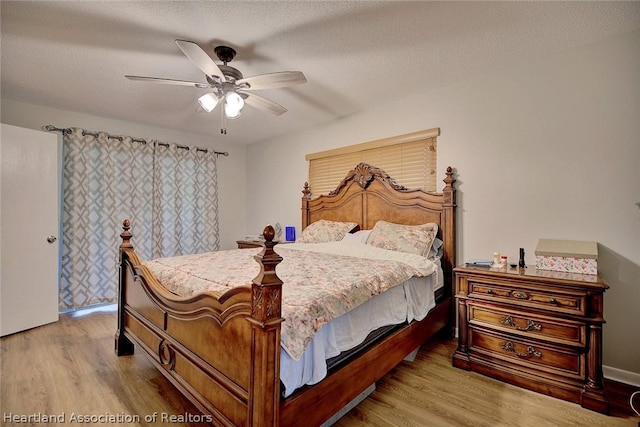 bedroom featuring ceiling fan, a textured ceiling, and light hardwood / wood-style flooring