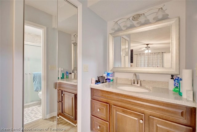 bathroom featuring curtained shower, ceiling fan, vanity, and hardwood / wood-style flooring