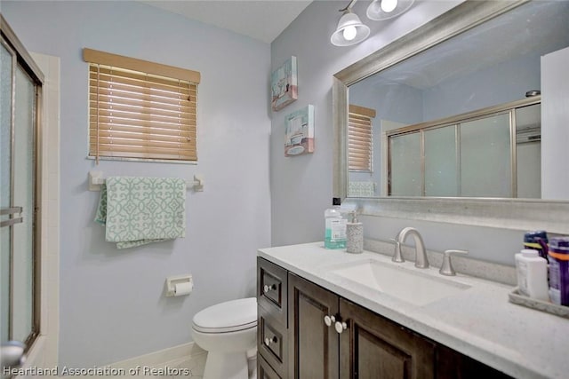 bathroom with tile patterned flooring, vanity, toilet, and an enclosed shower