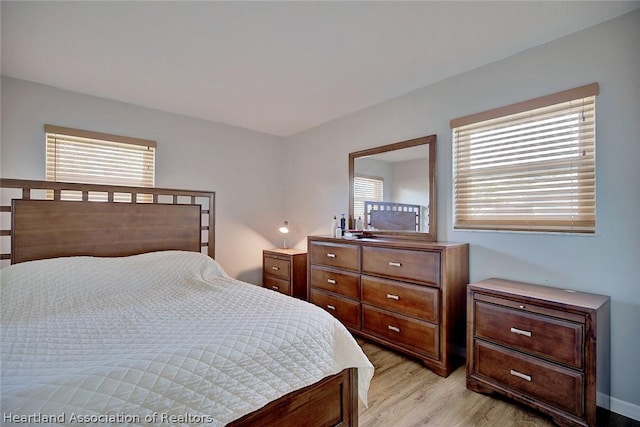 bedroom with multiple windows and light hardwood / wood-style flooring