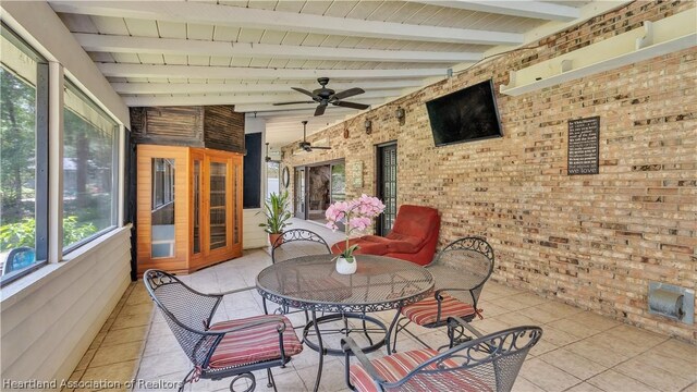 sunroom / solarium featuring ceiling fan and lofted ceiling with beams