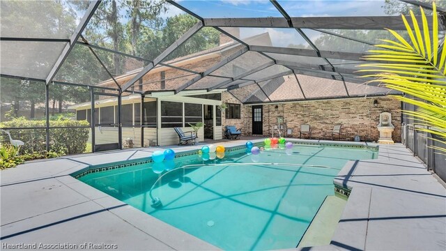 view of pool featuring glass enclosure