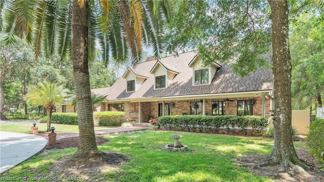 cape cod home featuring a front yard