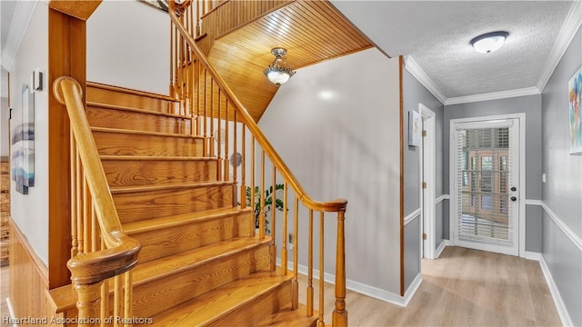 entryway with crown molding, light hardwood / wood-style floors, a textured ceiling, and wooden ceiling