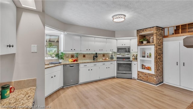 kitchen featuring white cabinets, light hardwood / wood-style flooring, decorative backsplash, a textured ceiling, and stainless steel appliances