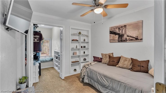 carpeted bedroom featuring ceiling fan and crown molding