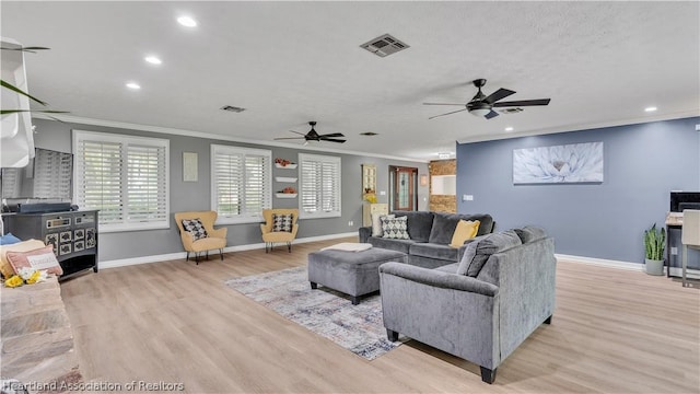 living room with crown molding, ceiling fan, light hardwood / wood-style floors, and a textured ceiling