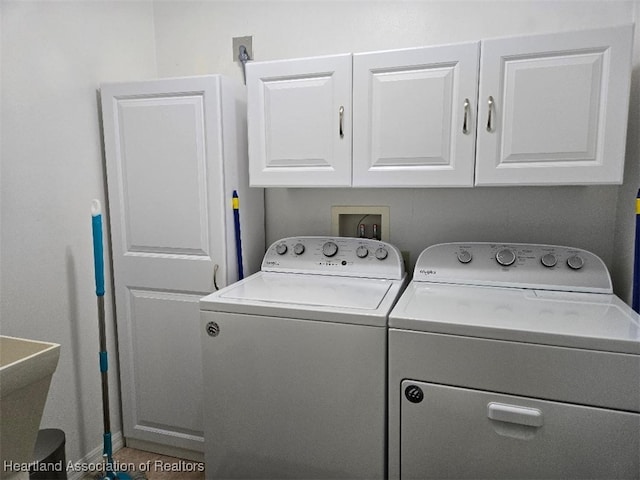 laundry area featuring cabinet space, a sink, and washer and clothes dryer