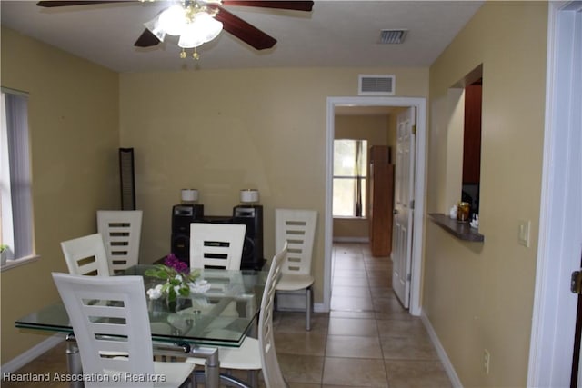 dining area featuring baseboards, visible vents, ceiling fan, and light tile patterned flooring