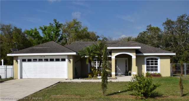 single story home with a garage, concrete driveway, fence, and stucco siding