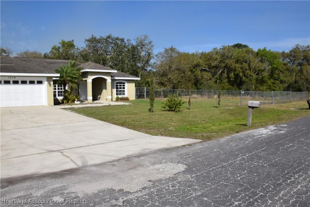 view of front of home with a garage, fence, concrete driveway, and a front yard