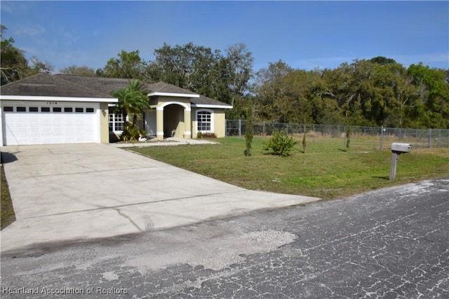view of front of property featuring a front yard, fence, driveway, and an attached garage