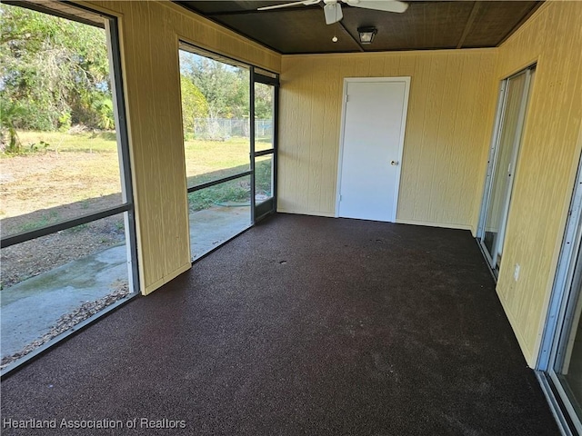 unfurnished sunroom with ceiling fan