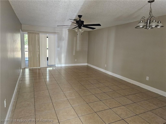 tiled empty room featuring ceiling fan with notable chandelier and a textured ceiling