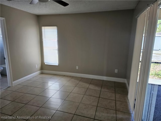 tiled spare room with a healthy amount of sunlight and a textured ceiling