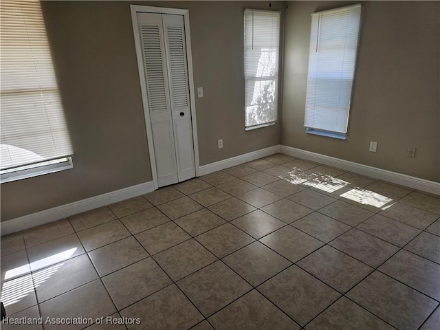 interior space with light tile patterned floors and a closet