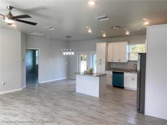 kitchen featuring dishwashing machine, a kitchen island, ceiling fan, pendant lighting, and white cabinetry