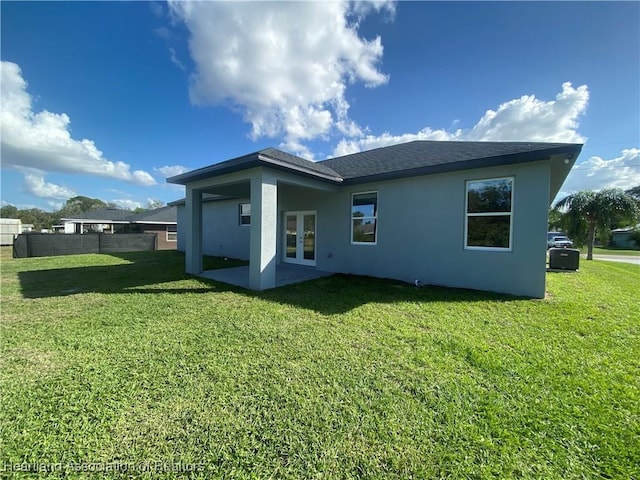 rear view of property with french doors and a yard