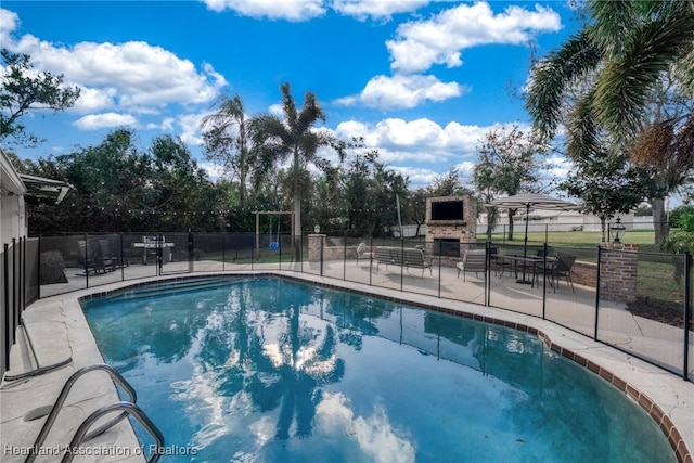 view of pool featuring exterior fireplace and a patio area