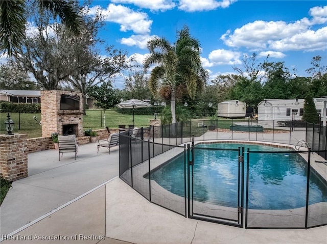 view of swimming pool with a patio area and an outdoor brick fireplace