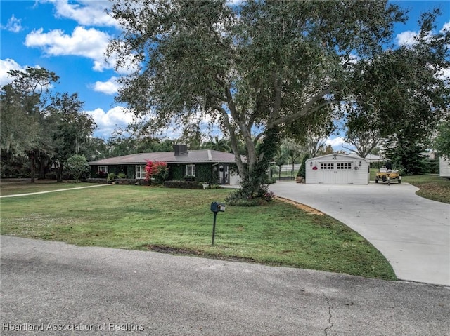 ranch-style home featuring an outbuilding and a front lawn