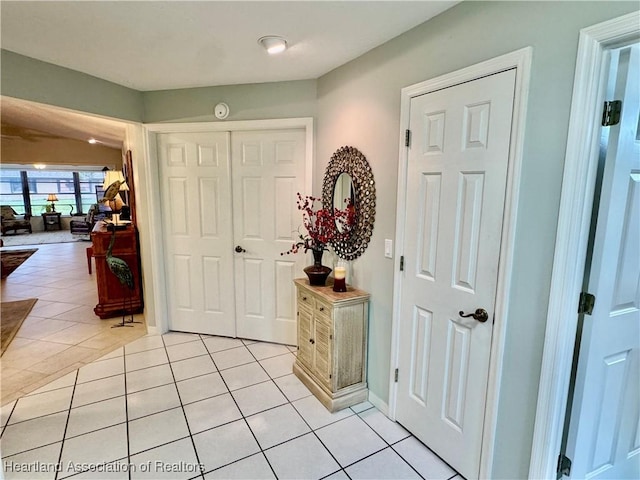 foyer entrance featuring baseboards and light tile patterned flooring