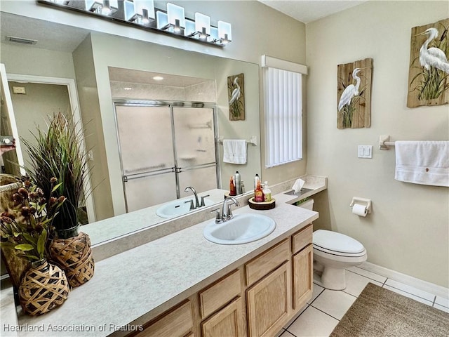 bathroom featuring vanity, toilet, tile patterned floors, and a shower with door