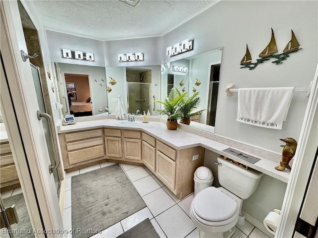 bathroom featuring a textured ceiling, a shower with shower door, tile patterned floors, and vanity