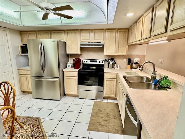 kitchen with light brown cabinets, ceiling fan, appliances with stainless steel finishes, sink, and light tile patterned floors