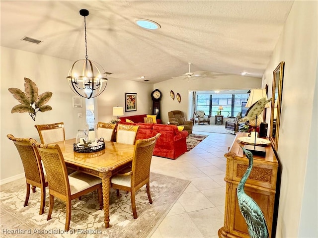 tiled dining room with ceiling fan with notable chandelier and vaulted ceiling