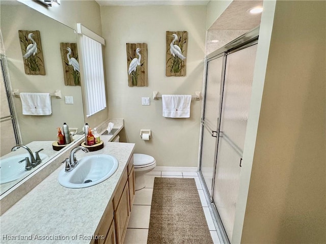 bathroom with toilet, tile patterned flooring, walk in shower, and vanity