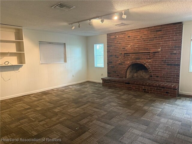 330 Sassafras Ave, Sebring, FL 33870 - unfurnished living room featuring baseboards, a fireplace, a textured ceiling, and track lighting