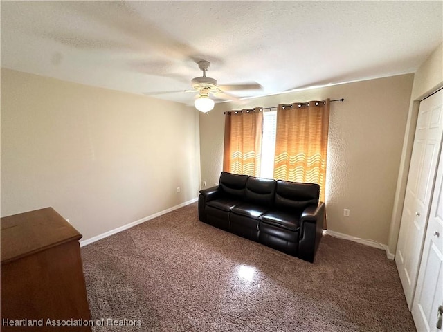 living room featuring baseboards, a textured ceiling, and ceiling fan