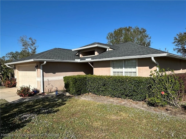 view of front of house with a shingled roof, a garage, and stucco siding